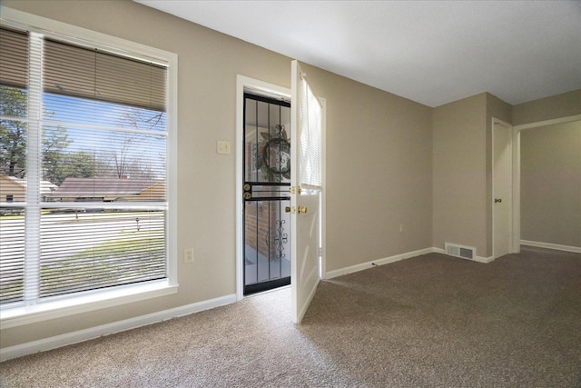 entryway with visible vents, baseboards, and carpet