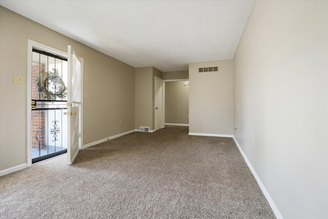 spare room featuring carpet flooring, baseboards, and visible vents