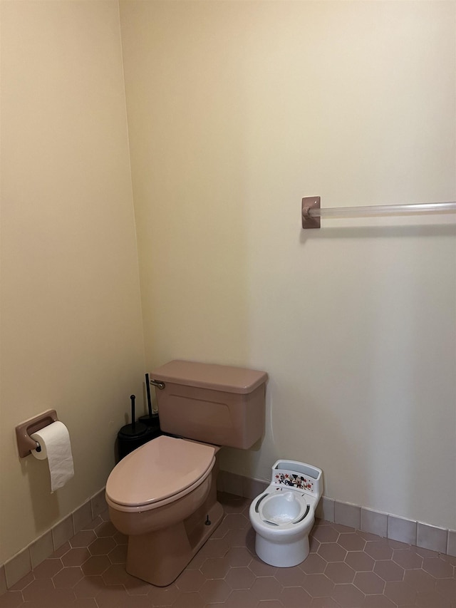 bathroom featuring tile patterned floors, baseboards, and toilet