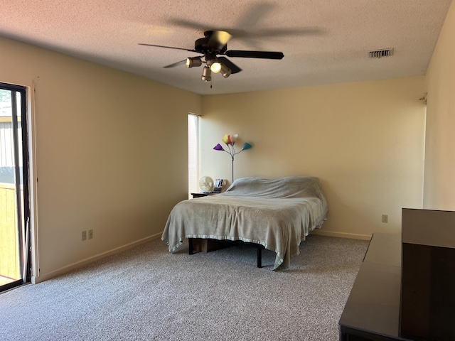carpeted bedroom featuring visible vents, baseboards, a textured ceiling, and ceiling fan