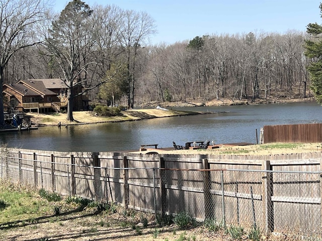property view of water with fence and a view of trees