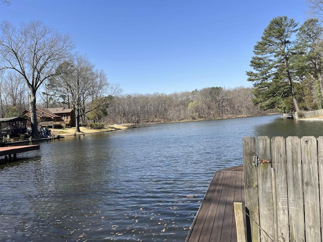 view of dock with a forest view and a water view