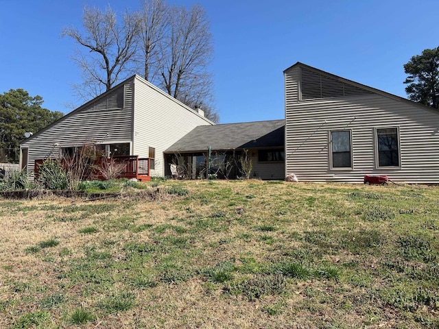 back of property featuring a deck and a yard