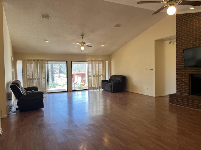 unfurnished living room featuring dark wood finished floors, a brick fireplace, visible vents, and ceiling fan