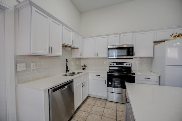 kitchen with a sink, tasteful backsplash, appliances with stainless steel finishes, light countertops, and light tile patterned floors