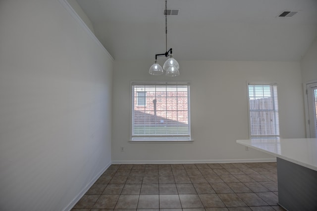 unfurnished dining area featuring lofted ceiling, visible vents, and tile patterned floors