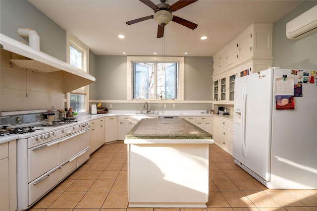 1860 Central Ave, Memphis, TN 38104 - kitchen featuring white appliances, a center island, light tile patterned floors, and a sink