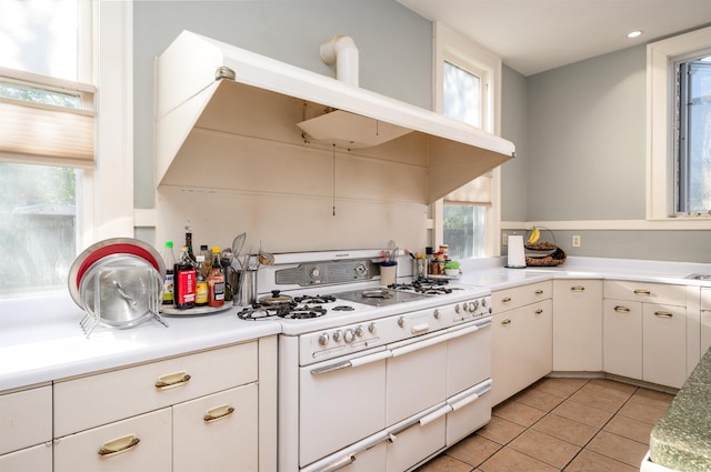 1860 Central Ave, Memphis, TN 38104 - kitchen with range with two ovens, white cabinetry, light tile patterned flooring, and light countertops