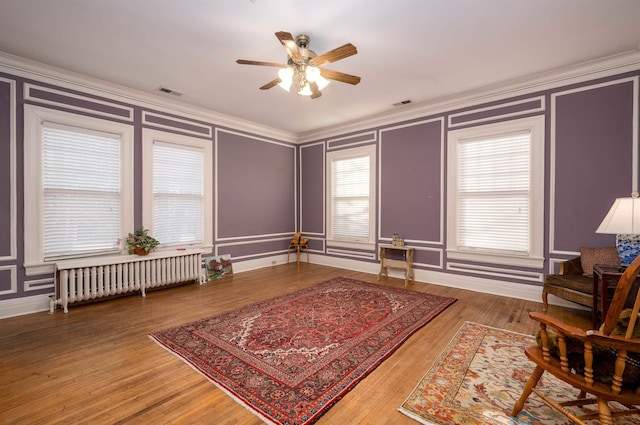 1860 Central Ave, Memphis, TN 38104 - living area with a decorative wall, radiator, a ceiling fan, and ornamental molding
