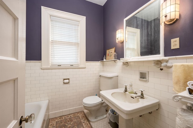 1860 Central Ave, Memphis, TN 38104 - bathroom featuring a wainscoted wall, a sink, tile patterned floors, toilet, and a washtub