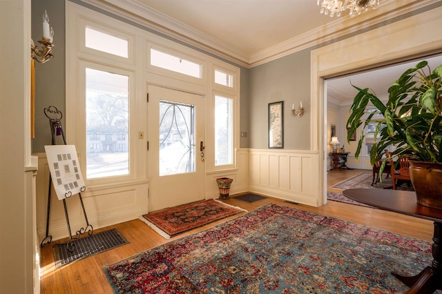 1860 Central Ave, Memphis, TN 38104 - foyer entrance featuring an inviting chandelier, hardwood / wood-style flooring, wainscoting, crown molding, and a decorative wall