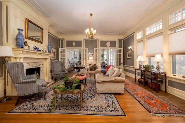1860 Central Ave, Memphis, TN 38104 - living area with wood-type flooring, a fireplace, crown molding, baseboards, and a chandelier