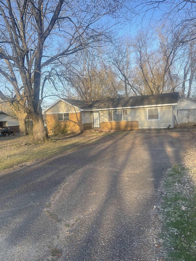 single story home featuring aphalt driveway