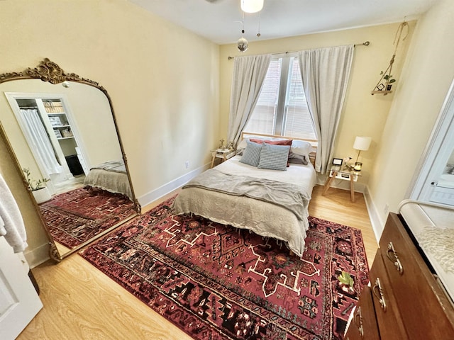 bedroom featuring a ceiling fan, wood finished floors, and baseboards