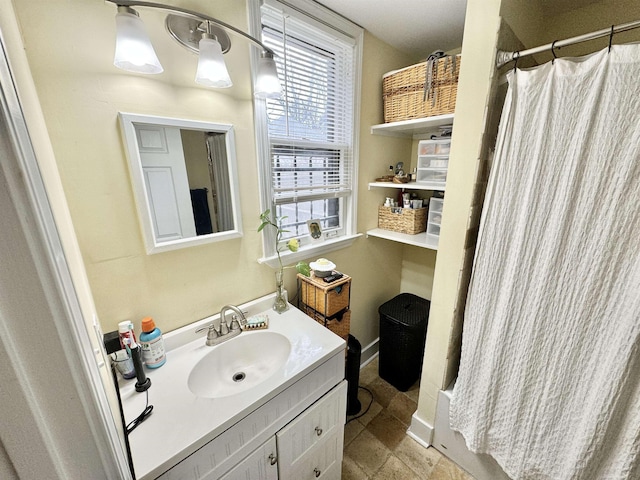 full bathroom featuring a shower with shower curtain, baseboards, and vanity