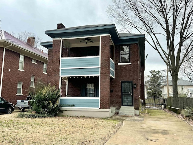 view of front of property with brick siding, driveway, a chimney, and fence