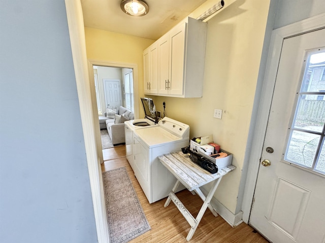 laundry room featuring cabinet space, washer and dryer, and light wood-type flooring