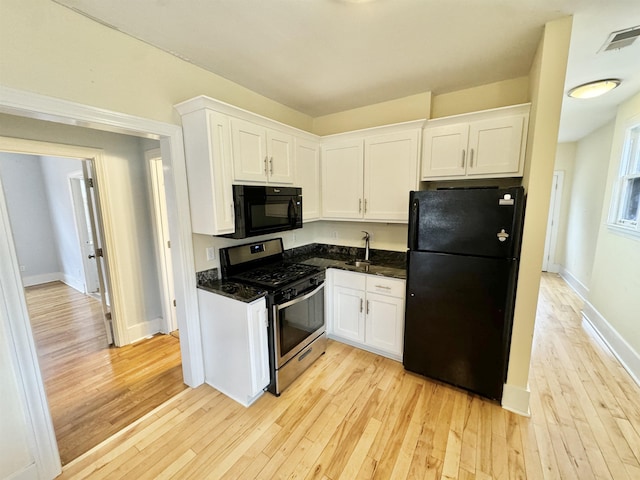 kitchen with black appliances, white cabinets, and light wood-style floors