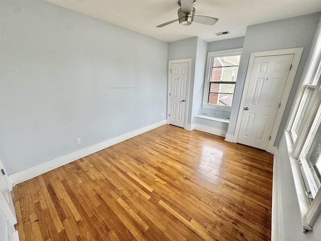 unfurnished bedroom with visible vents, ceiling fan, light wood-type flooring, and baseboards