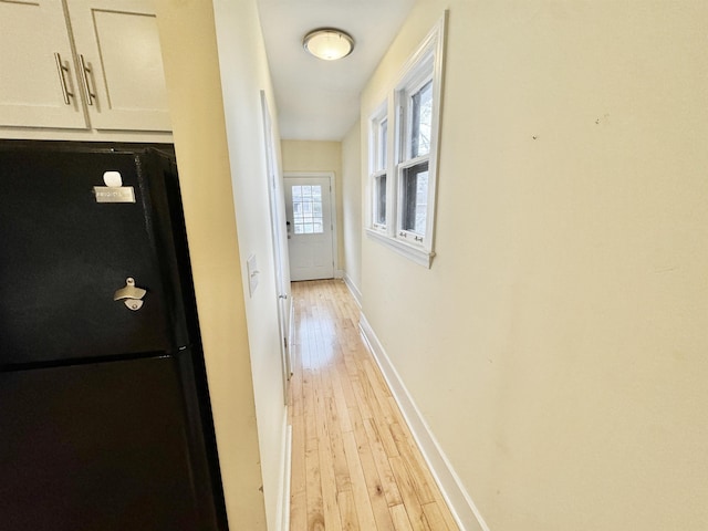 hall featuring baseboards and light wood-style floors