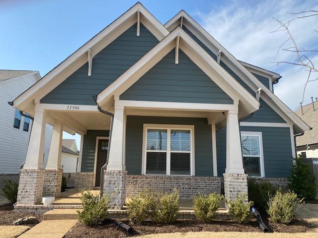 craftsman inspired home featuring brick siding and covered porch