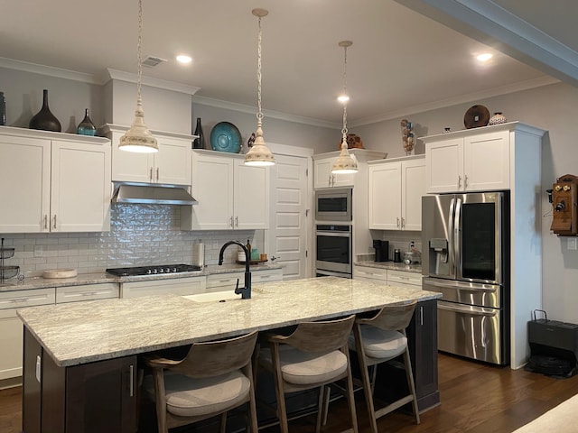 kitchen featuring under cabinet range hood, stainless steel appliances, dark wood-style flooring, and a sink