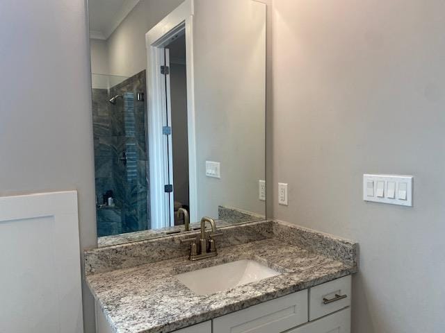 full bath with tiled shower and vanity