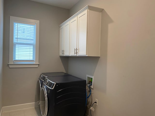 washroom featuring tile patterned floors, cabinet space, baseboards, and separate washer and dryer