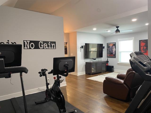 workout room with baseboards, vaulted ceiling, recessed lighting, wood finished floors, and a ceiling fan