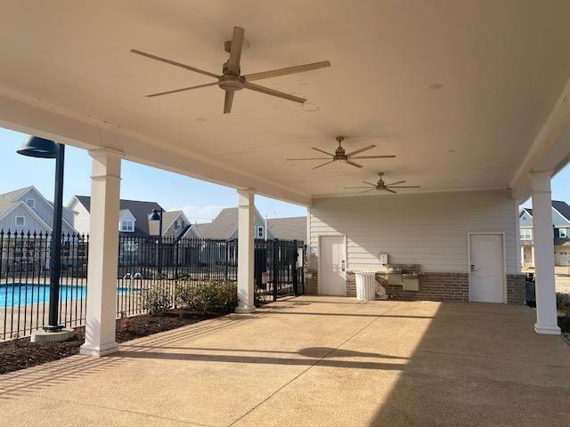 view of patio featuring a ceiling fan, a community pool, and fence