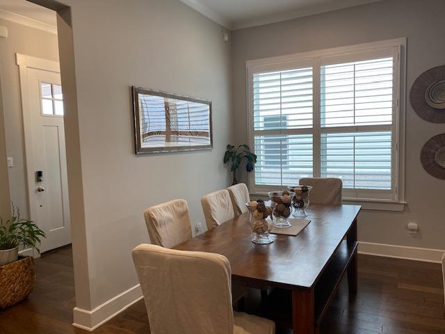 dining space with dark wood finished floors, baseboards, and ornamental molding