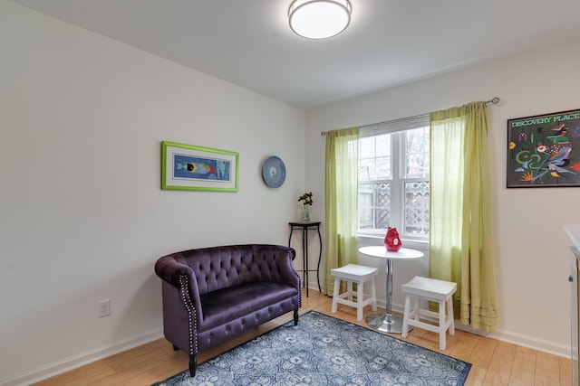 sitting room with baseboards and hardwood / wood-style flooring