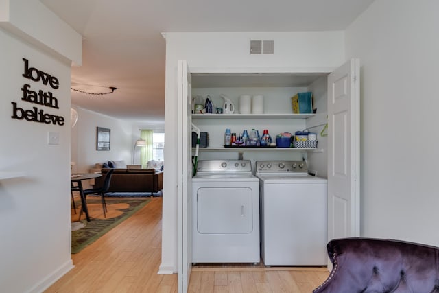 washroom featuring visible vents, washing machine and dryer, laundry area, and light wood finished floors