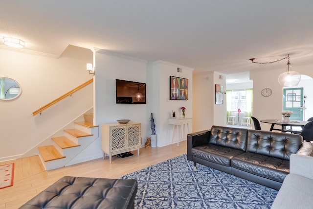 living area featuring visible vents, ornamental molding, stairs, and wood finished floors