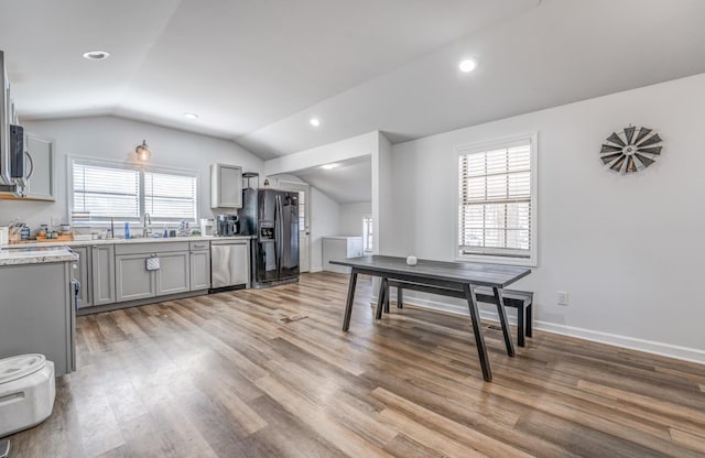 interior space with plenty of natural light, dishwasher, black fridge, and gray cabinetry