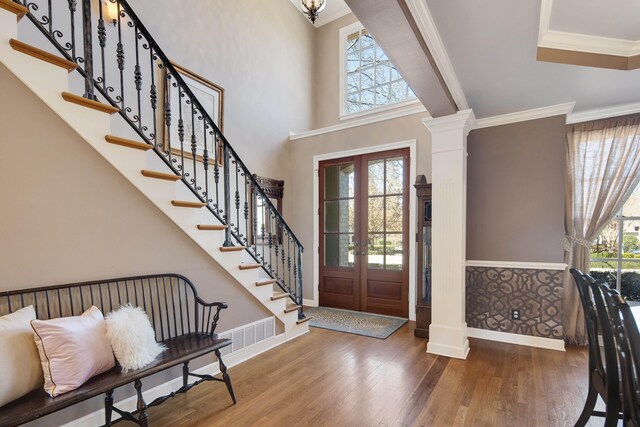 foyer entrance featuring a wealth of natural light, wood finished floors, and ornamental molding