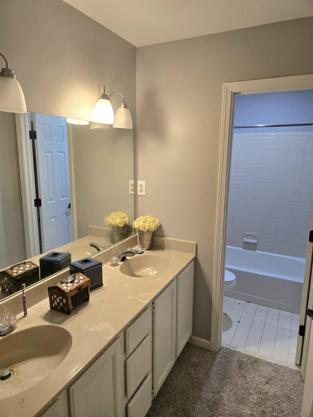 bathroom with a sink, tile patterned flooring, toilet, and double vanity