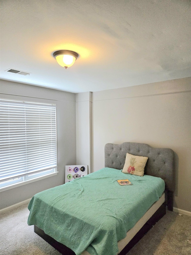 bedroom featuring baseboards, carpet flooring, and visible vents