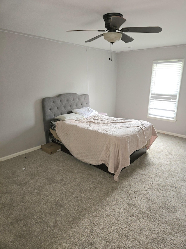 carpeted bedroom featuring baseboards and ceiling fan