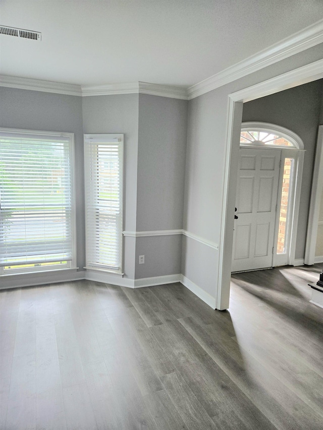 entryway with visible vents, ornamental molding, baseboards, and wood finished floors