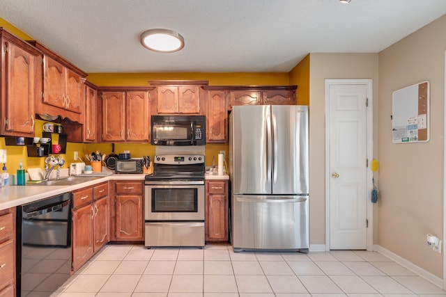 9995 Woodland Birch Dr, Lakeland, TN 38002 - kitchen with light tile patterned floors, black appliances, light countertops, and baseboards