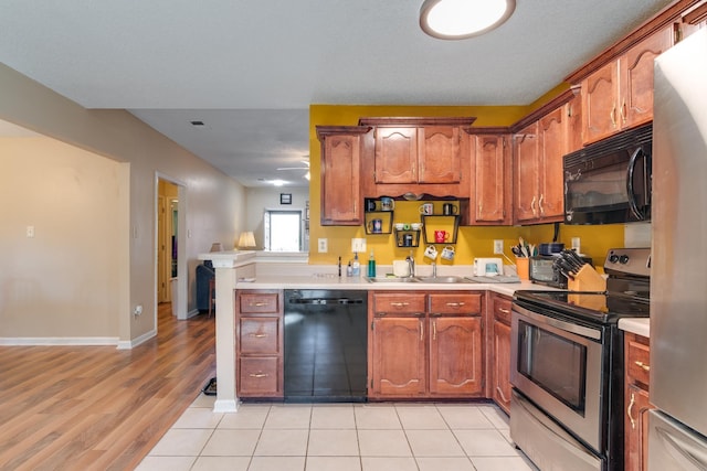9995 Woodland Birch Dr, Lakeland, TN 38002 - kitchen featuring a sink, brown cabinets, black appliances, and light countertops