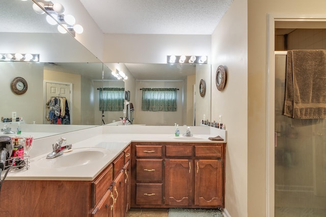 9995 Woodland Birch Dr, Lakeland, TN 38002 - bathroom with a textured ceiling, double vanity, a stall shower, and a sink