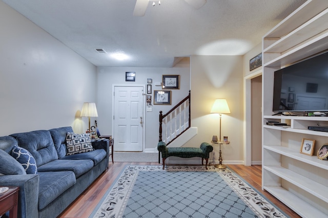 9995 Woodland Birch Dr, Lakeland, TN 38002 - living room featuring stairway, a ceiling fan, wood finished floors, visible vents, and baseboards