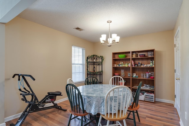 9995 Woodland Birch Dr, Lakeland, TN 38002 - dining room with visible vents, a notable chandelier, a textured ceiling, wood finished floors, and baseboards