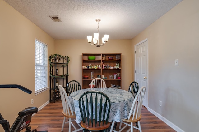 9995 Woodland Birch Dr, Lakeland, TN 38002 - dining room with dark wood-type flooring, a notable chandelier, visible vents, and a textured ceiling
