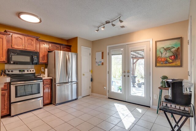 9995 Woodland Birch Dr, Lakeland, TN 38002 - kitchen with light tile patterned floors, french doors, appliances with stainless steel finishes, a textured ceiling, and brown cabinets