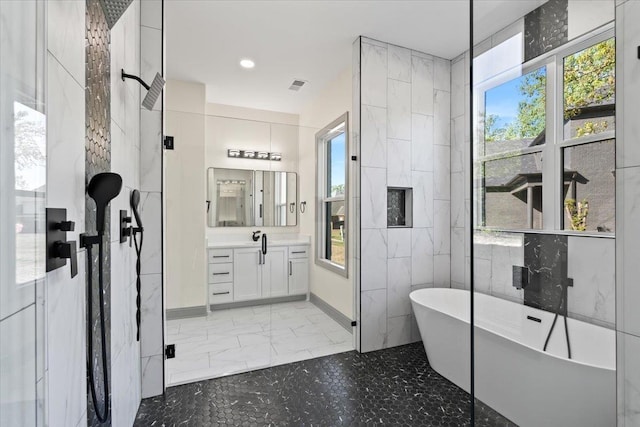 bathroom featuring walk in shower, a freestanding tub, a wealth of natural light, and vanity