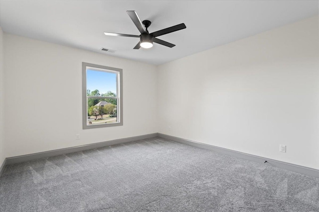 carpeted spare room featuring visible vents, a ceiling fan, and baseboards
