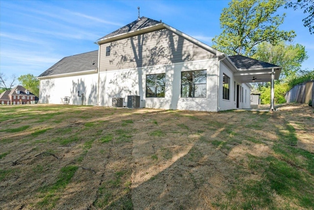 back of property featuring central AC unit, a yard, and ceiling fan